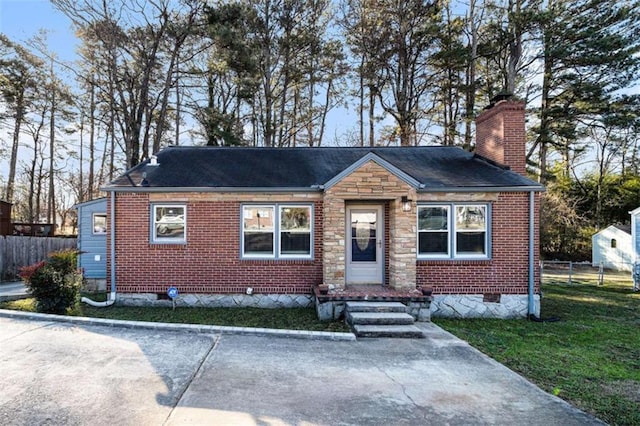 bungalow-style house with crawl space, a chimney, fence, and brick siding