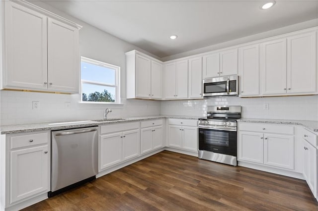 kitchen featuring a sink, white cabinetry, decorative backsplash, and stainless steel appliances