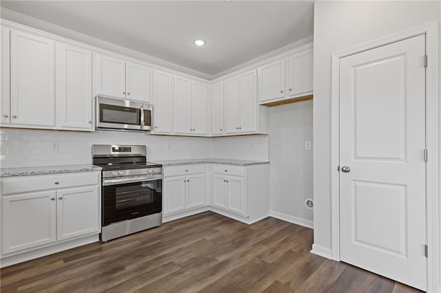 kitchen with decorative backsplash, stainless steel appliances, and white cabinetry