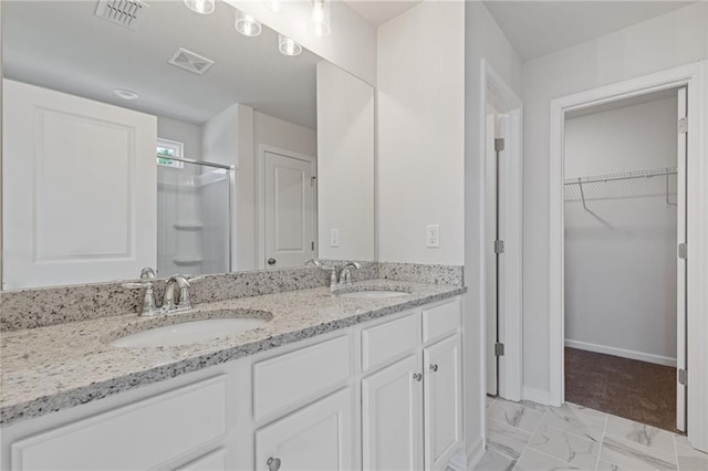full bathroom featuring visible vents, a shower stall, and a sink