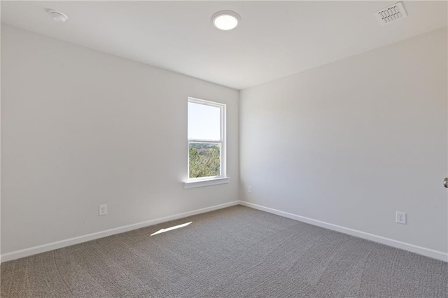 carpeted empty room featuring baseboards and visible vents