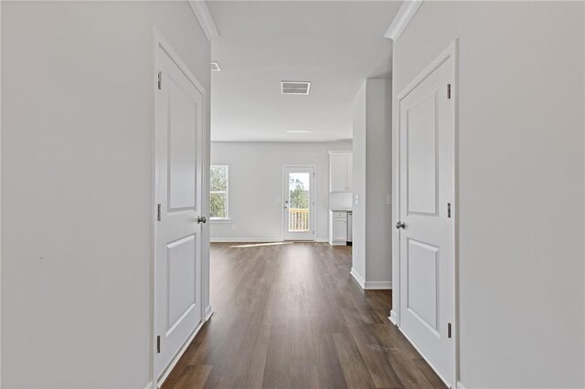 hall featuring baseboards, visible vents, and dark wood finished floors