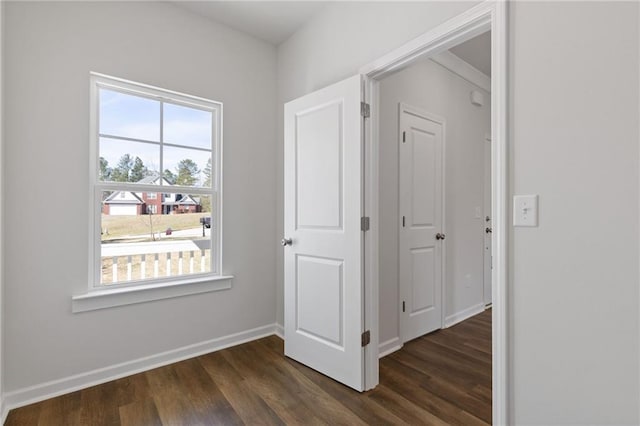 hall featuring baseboards and dark wood-type flooring