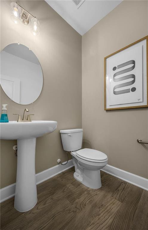 bathroom featuring toilet and wood-type flooring