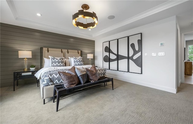 carpeted bedroom with crown molding, a raised ceiling, and wooden walls