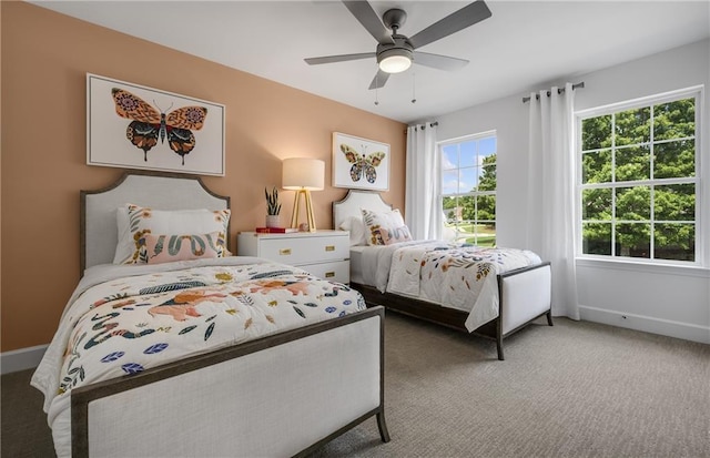 carpeted bedroom with ceiling fan and multiple windows