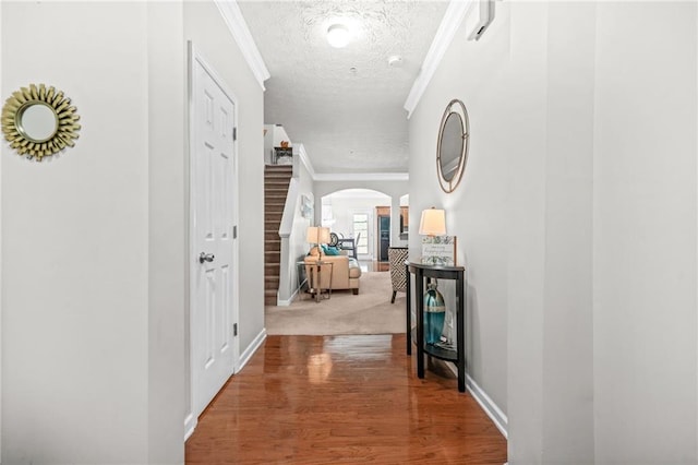 1622 Honeysuckle Path, Conyers, GA 30012 - hallway with a textured ceiling, ornamental molding, arched walkways, baseboards, and wood finished floors