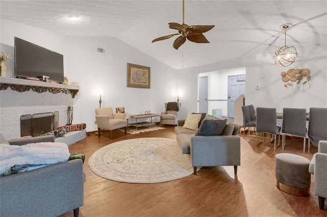 652 Post Oak Rd, Jonesboro, GA 30238 - living room with vaulted ceiling, a ceiling fan, wood finished floors, and a brick fireplace