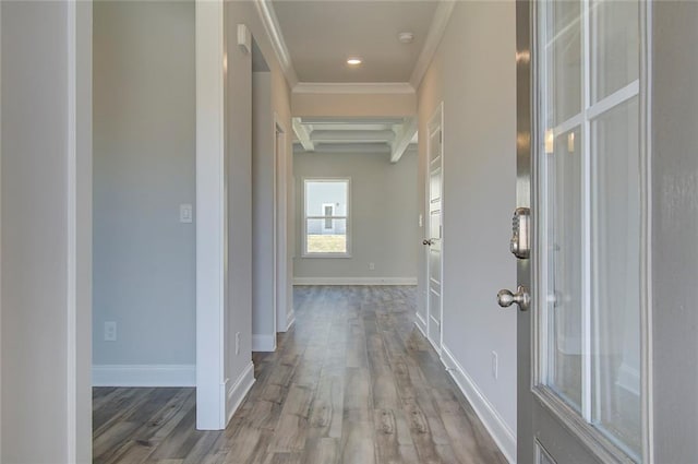 hall featuring beamed ceiling, ornamental molding, coffered ceiling, and light wood-type flooring