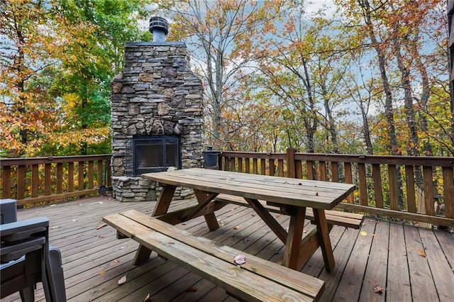 deck with an outdoor stone fireplace