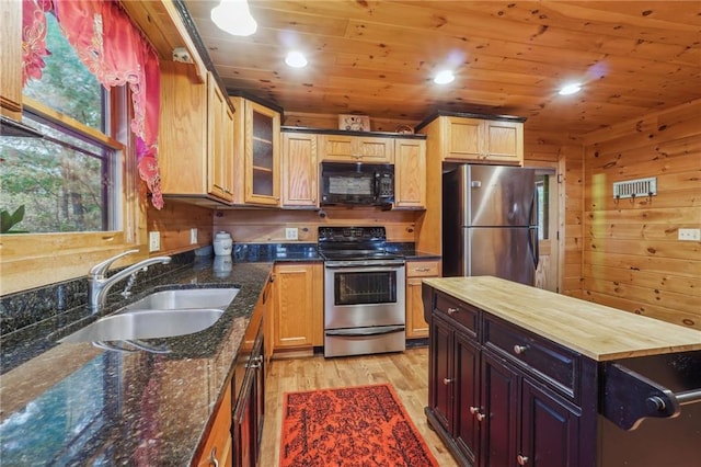 kitchen with sink, light wood-type flooring, wooden walls, stainless steel appliances, and wooden ceiling