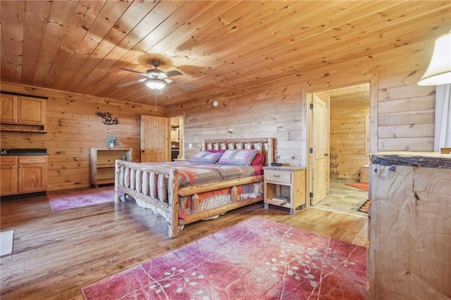 bedroom featuring wood ceiling, wood walls, light hardwood / wood-style floors, and ceiling fan