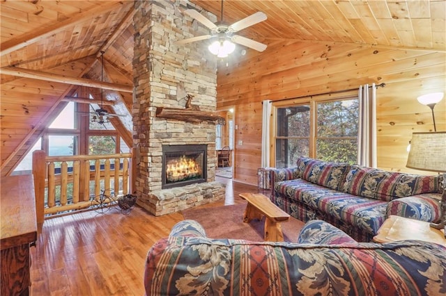 living room with ceiling fan, wooden walls, light hardwood / wood-style flooring, and wood ceiling