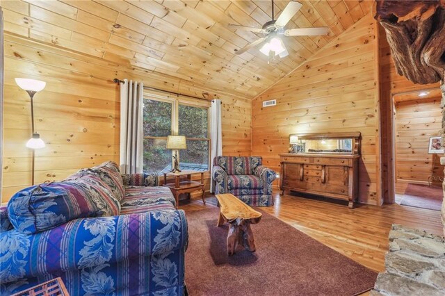 living room with wood walls, light hardwood / wood-style flooring, wood ceiling, ceiling fan, and lofted ceiling