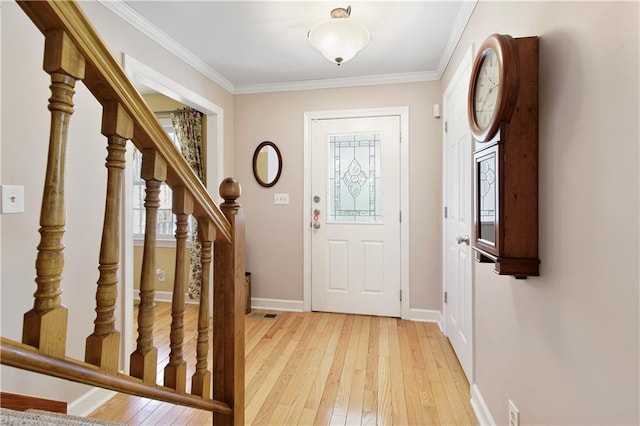 foyer entrance featuring ornamental molding and light wood-type flooring