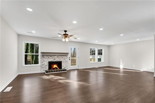 unfurnished living room featuring dark hardwood / wood-style floors, ceiling fan, and a tiled fireplace