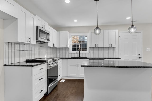 kitchen featuring white cabinetry, sink, pendant lighting, and appliances with stainless steel finishes