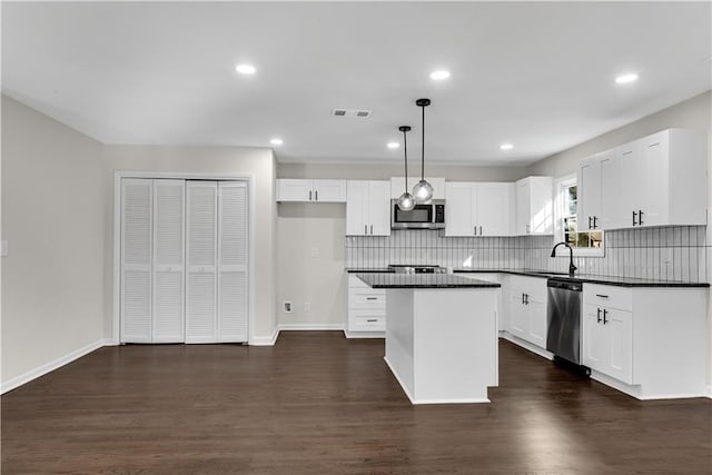 kitchen with pendant lighting, white cabinetry, and appliances with stainless steel finishes