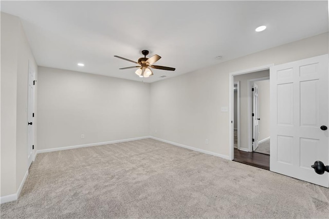 spare room featuring light colored carpet and ceiling fan