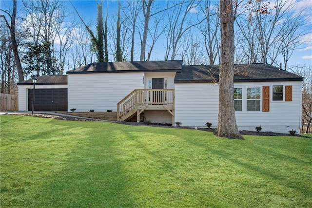 back of property with a lawn and a garage