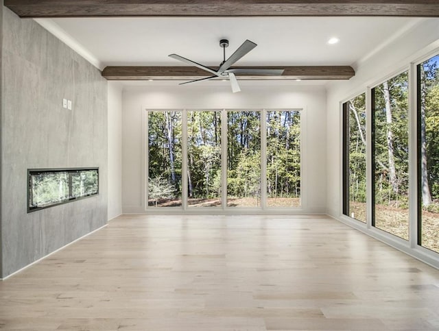 unfurnished room with light hardwood / wood-style flooring, beam ceiling, and ceiling fan