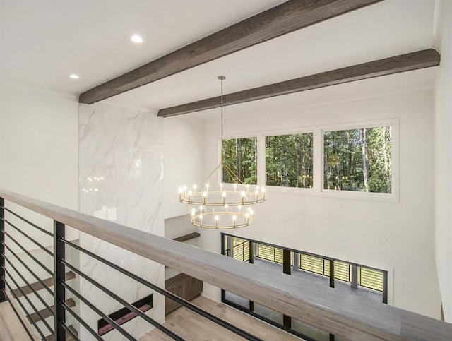 hallway featuring beam ceiling, a chandelier, and hardwood / wood-style flooring