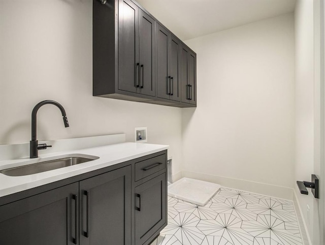 clothes washing area featuring washer hookup, light tile patterned floors, cabinets, and sink