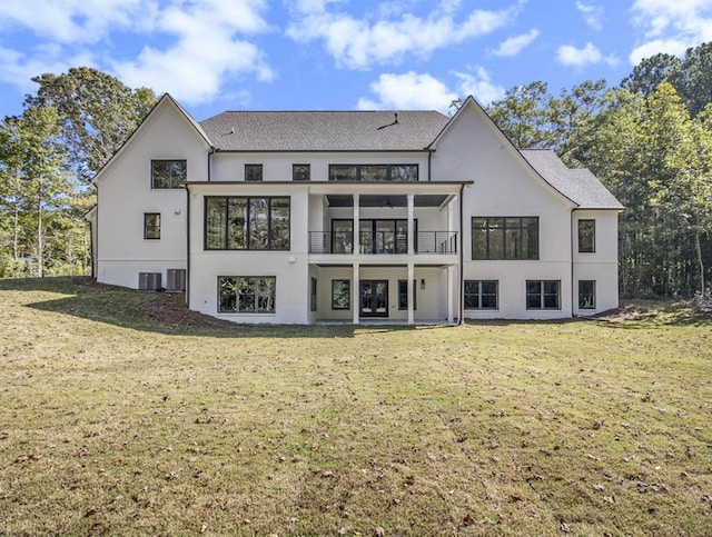 rear view of house featuring a lawn and a balcony