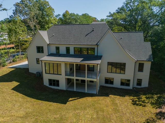 back of house featuring cooling unit, a yard, and a balcony