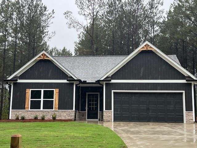 craftsman house with a garage and a front yard