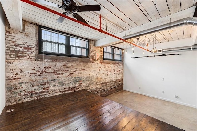 unfurnished room with brick wall, ceiling fan, and wood-type flooring