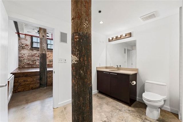 bathroom featuring toilet, vanity, and concrete floors