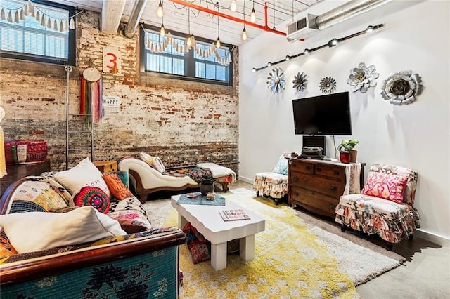 living room with brick wall, a high ceiling, and plenty of natural light