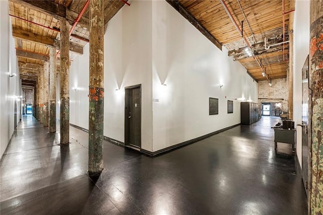 corridor with beamed ceiling, high vaulted ceiling, and wooden ceiling