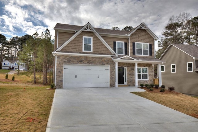 craftsman-style home featuring a garage, stone siding, concrete driveway, and a front yard