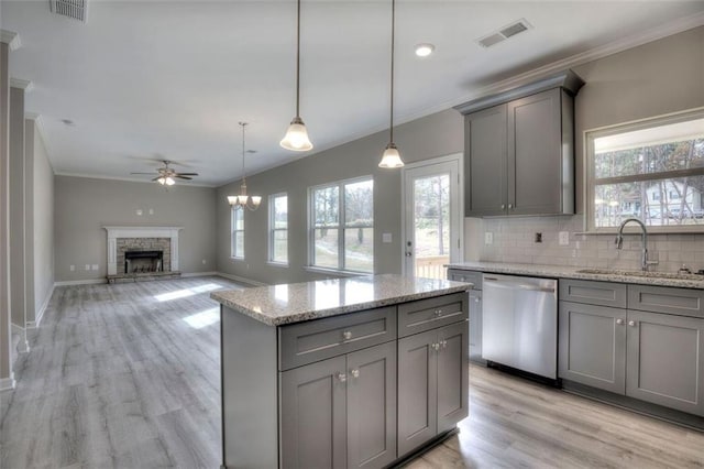 kitchen with stainless steel dishwasher, gray cabinets, a sink, crown molding, and ceiling fan