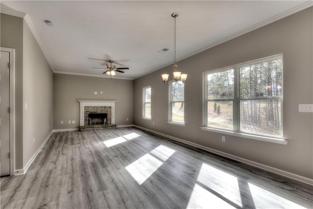 unfurnished living room featuring ceiling fan, crown molding, healthy amount of natural light, wood finished floors, and baseboards