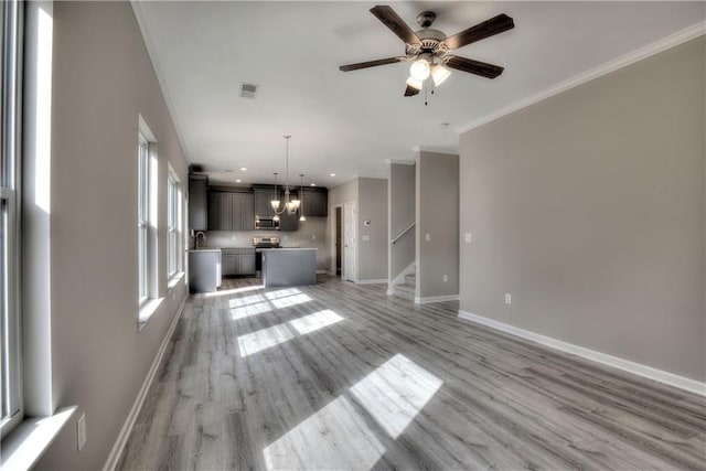 unfurnished living room featuring crown molding, stairs, ceiling fan, baseboards, and light wood-type flooring
