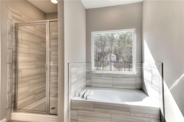 bathroom featuring a garden tub and a shower stall