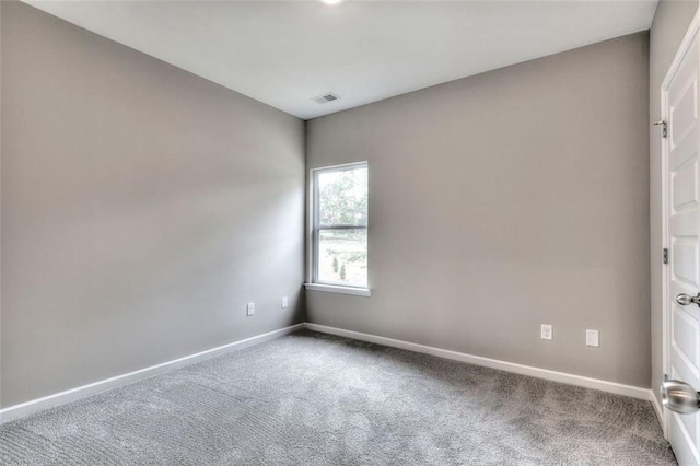 carpeted empty room featuring baseboards