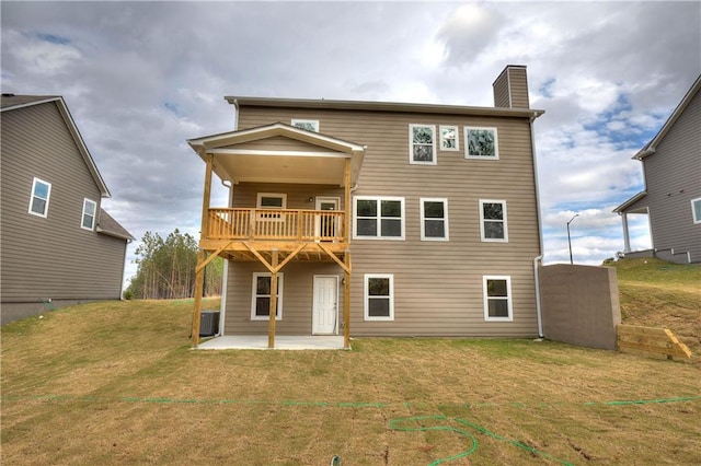 rear view of house featuring a patio, a chimney, a lawn, central AC unit, and a balcony