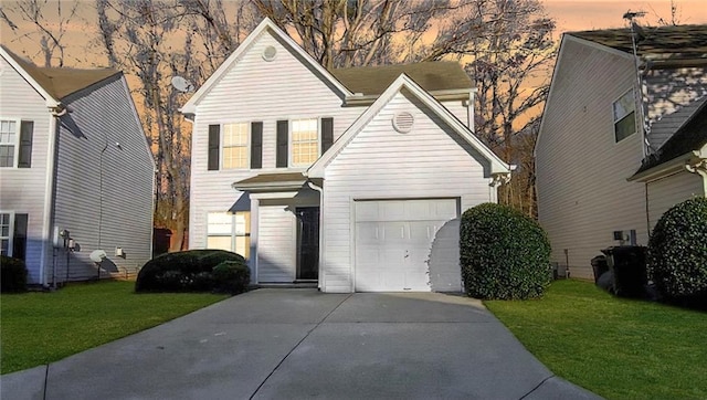 traditional-style home featuring a garage, concrete driveway, and a yard