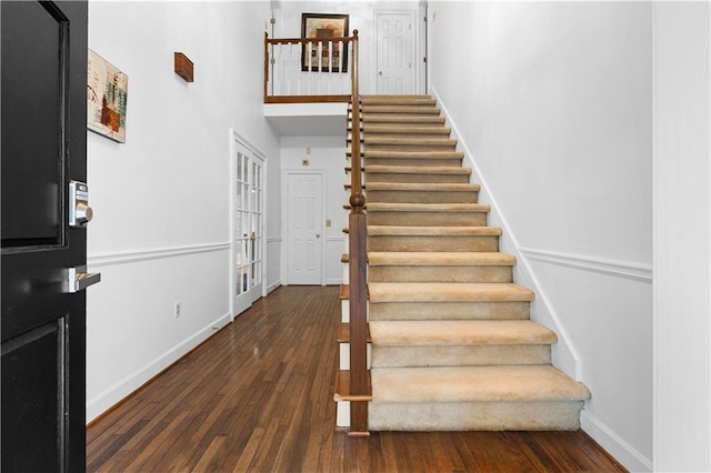 foyer entrance featuring french doors, a towering ceiling, and dark hardwood / wood-style floors