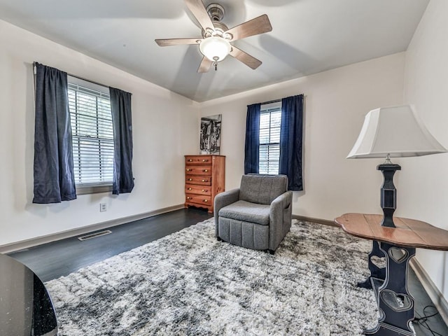 living area with ceiling fan and dark hardwood / wood-style floors