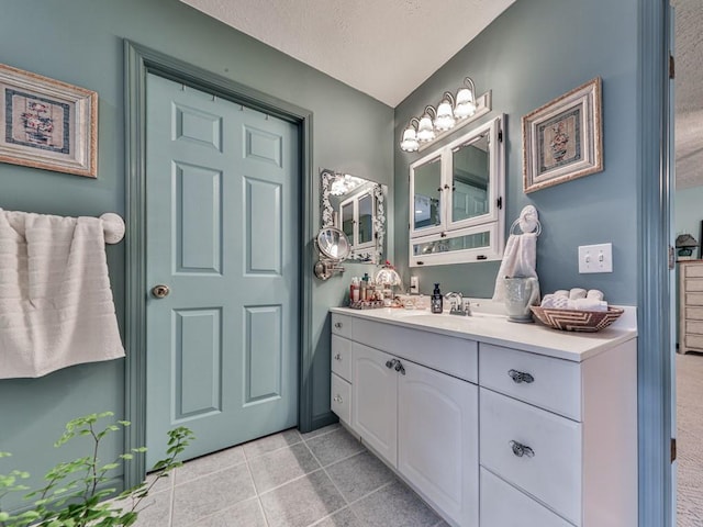 bathroom featuring tile patterned flooring, vanity, and a textured ceiling