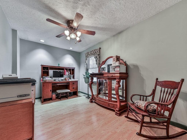 office area with ceiling fan, light hardwood / wood-style floors, and a textured ceiling