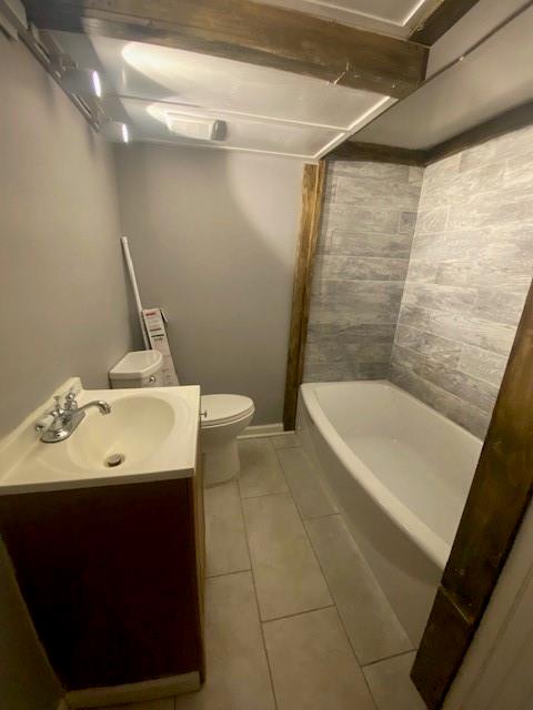 full bathroom with tiled shower / bath combo, tile flooring, toilet, and vanity