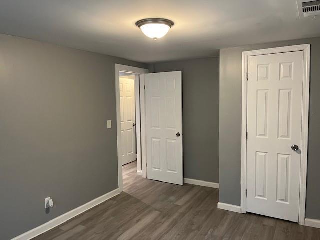 unfurnished bedroom featuring dark hardwood / wood-style floors