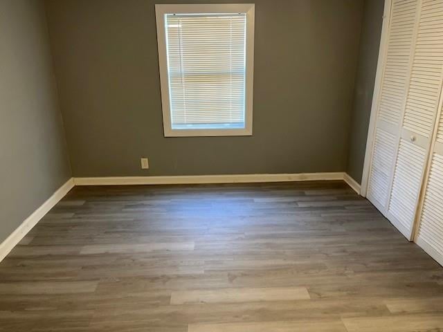 unfurnished bedroom with dark hardwood / wood-style flooring and a closet