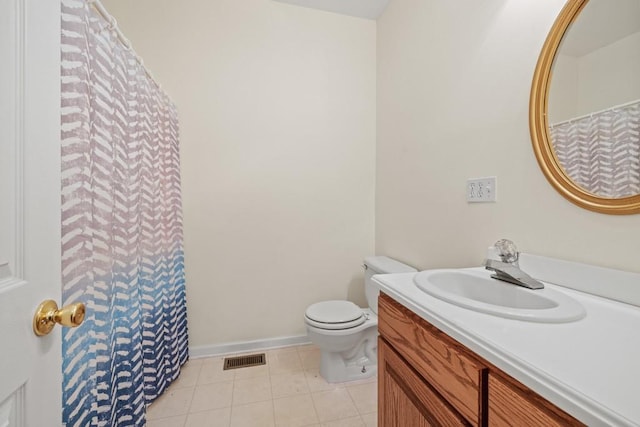 bathroom with tile patterned flooring, vanity, and toilet